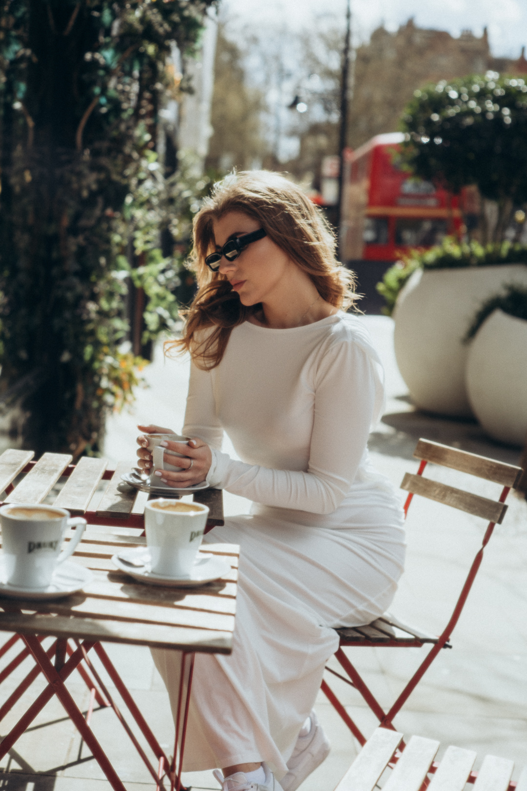 Photography session — woman in a white dress enjoying coffee at a London café